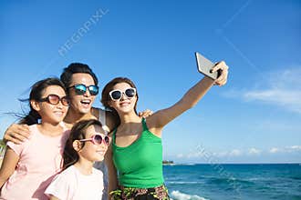 Happy family taking a selfie at the beach
