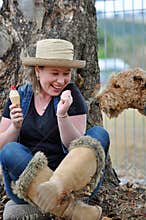 Clever sneaky pet dog sneaking up to pinch ice cream that pretty young girl eating