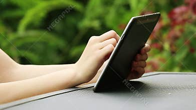 Close up of woman hands using tablet computer outdoors