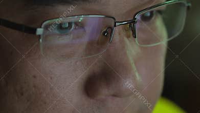 Close-up of asian man with social media reflecting in his glass lenses