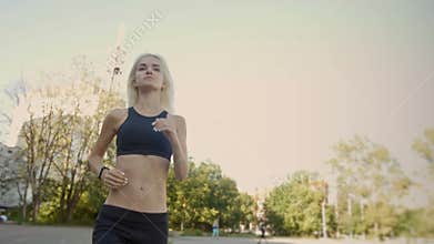 Beautiful fit and healthy blonde woman road running with fitness tracker