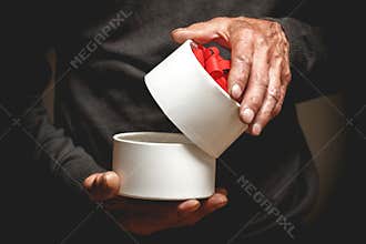 Gift in hands of the elderly man