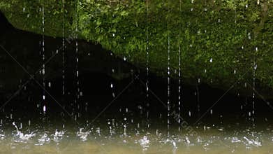 Slow motion spring water dribbling into river, RED 4K