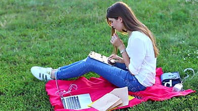 Young girl eating fast food and enjoys the tablet, thinking