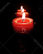 Three pink candles burning brightly on black background