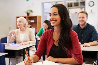 Hispanic woman studying at adult education class looking up