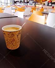 Paper cup of coffee on cafeteria table top