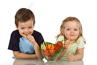 Happy kids eating vegetables