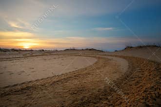 Motocross and auto sport track with sunset sky background.