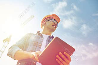 Builder in hardhat with tablet pc at construction
