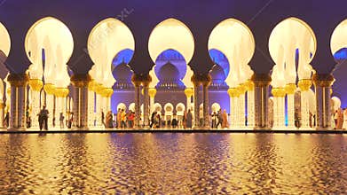 UAE, 2017: Mosque reflected in the water. Evening lights