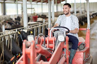 Man or farmer driving tractor at farm