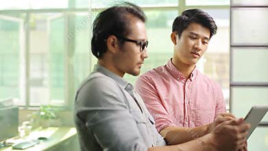 Asian corporate executives discussing business in office