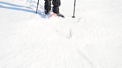 Man legs with snowshoes walk in snow. Detail of winter hike in snowdrift, snowshoeing with trekking poles and shoe cover in powder