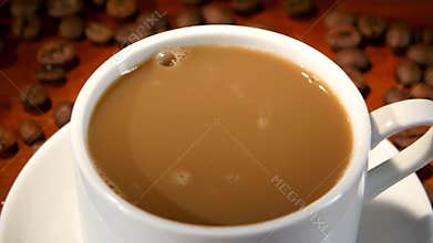 In latte added a lump of sugar and stir, closeup