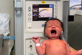 Newborn baby girl held up shortly after birth