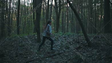 Little European girl with a long hair, brown jacket, black pants, sneakers and bright blue scarf. A scared little child