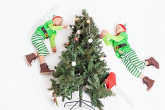 Flying little elves decorating Christmas tree. Santa`s helpers