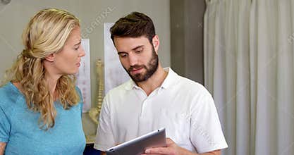 Physiotherapist showing digital tablet to woman