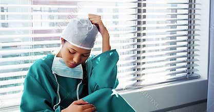 Sad nurse sitting on the floor