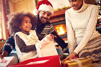 Happy Afro-American family opening Christmas presents