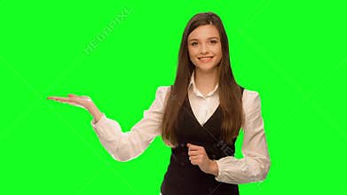 Woman showing your product or message smiling happy Isolated on green screen chroma key. Green screen keying in a single