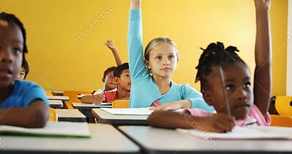 School kids raising hand in classroom