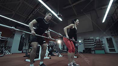 Strong athletic couple working out in a gym
