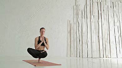 Woman practicing yoga - ardha baddha padma padangusthasana - balancing on toes