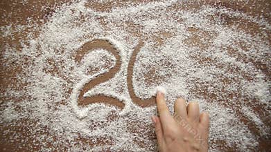 The girl draws figures on coconut flakes. The girl draws on coconut flakes. New year 2017.