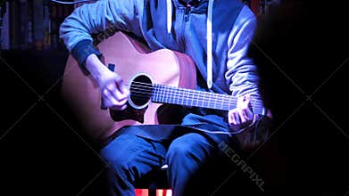 Concert in night club - musician on concert plays acoustic guitar