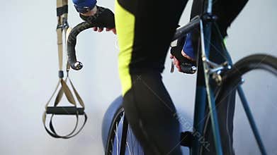 Close-up of sportsman legs working out on bicycle indoors in the gym.
