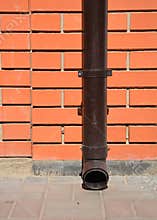 House rain gutter downspout with wall holder without water drainage on the pavement