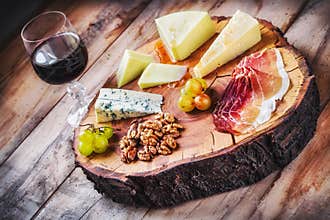 Rustic Mediterranean cheese board and a glass of red wine