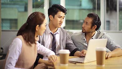 Young asian corporate executives discussing business in office