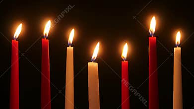 Candles flicker in the darkness
