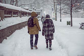 People walking on New York City Manhattan street during strong snow storm blizzard and cold weather
