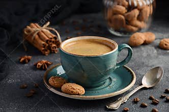 Cup of fresh coffee with Amaretti cookies on dark background