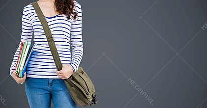 College student with books and bags against grey background