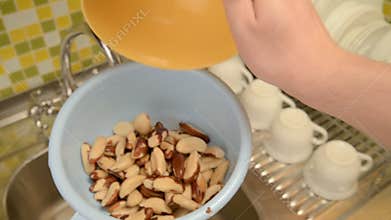 Wash the nuts in the colander in the kitchen.