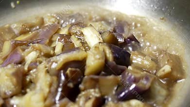 Close up of a woman cooking eggplant and garlic hot pot