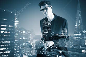 Side view of young businessman using laptop on abstract city background.