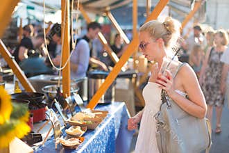 Woman buying meal at street food festival.