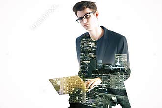 Side view of young man using laptop on abstract city background.