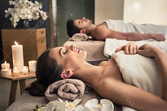 Man and woman lying down on massage beds at Asian wellness center