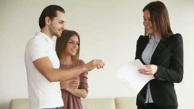 Young happy couple getting keys from new house