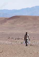 Man carrying water through desert