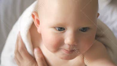 Blonde baby girl looks at camera and laughing