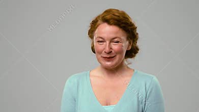 Mid aged red haired woman showing happy emotions, ogling.