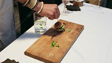 Waiter serving mini burgers at party